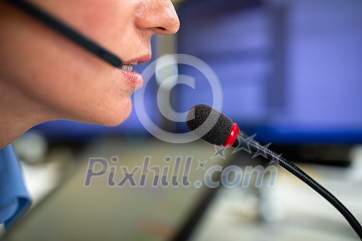 Call centre employee communicating over phone using an external microphone for better sounf and ergonomics Call centre employee communicating over phone using an external microphone for better sounf and ergonomics