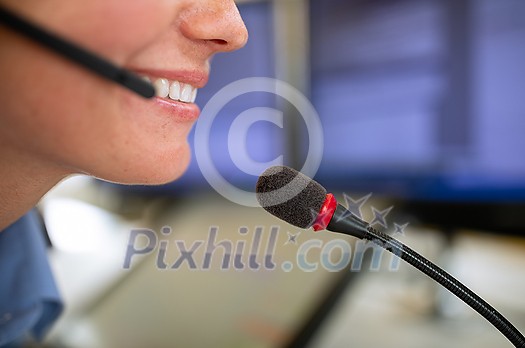 Call centre employee communicating over phone using an external microphone for better sounf and ergonomics Call centre employee communicating over phone using an external microphone for better sounf and ergonomics