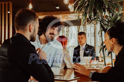 Group of friends hanging out in a coffee shop with a laptop amongst them. Happy young people sitting at restaurants using a laptop Group of friends hanging out in a coffee shop with a laptop amongst them. Happy young people sitting at restaurants using a laptop