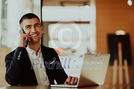 businessman sitting at the cafeteria with a laptop and smartphone. Businessman texting on smartphone while sitting in a pub restaurant. Businessman working and checking email on the computer. businessman sitting at the cafeteria with a laptop and smartphone. Businessman texting on smartphone while sitting in a pub restaurant. Businessman working and checking email on the computer.