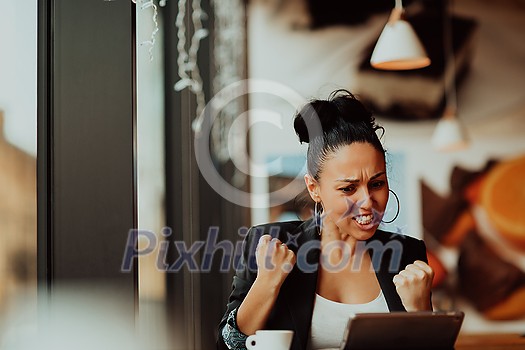 a woman sits in a cafe with her arms raised and celebrating a job well done a woman sits in a cafe with her arms raised and celebrating a job well done