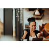 a woman sits in a cafe with her arms raised and celebrating a job well done