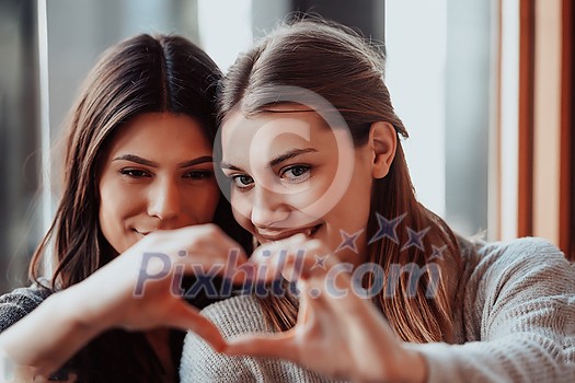 two lgbt girls romantically embracing sitting in a modern cafe two lgbt girls romantically embracing sitting in a modern cafe
