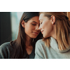 two lgbt girls romantically embracing sitting in a modern cafe