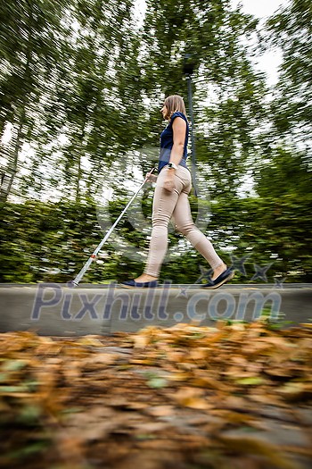 Blind woman walking on city streets, using her white cane Blind woman walking on city streets, using her white cane