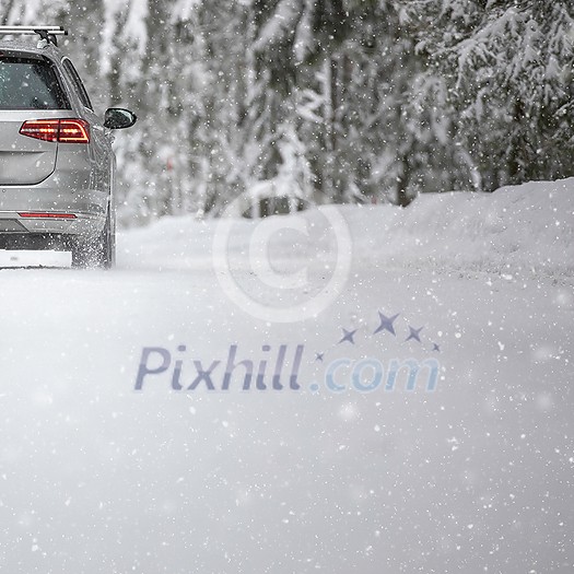 Car on a snowy winter road amid forests - using its four wheel drive capacities to get through the snow Car on a snowy winter road amid forests - using its four wheel drive capacities to get through the snow