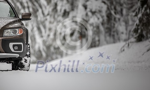 Car on a snowy winter road amid forests - using its four wheel drive capacities to get through the snow Car on a snowy winter road amid forests - using its four wheel drive capacities to get through the snow