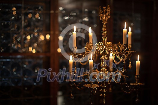 Splendid chandelier with lit candles in a beautiful room of an old mansion Splendid chandelier with lit candles in a beautiful room of an old mansion
