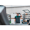 Heavy Industry Engineering Factory Interior with Industrial Worker Using Angle Grinder and Cutting a Metal Tube. Contractor in Safety Uniform and Hard Hat Manufacturing Metal Structures. High quality photo
