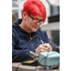 Industrial worker woman soldering cables of manufacturing equipment in a factory. High quality photo