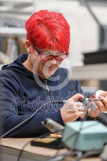 Industrial worker woman soldering cables of manufacturing equipment in a factory. High quality photo Industrial worker woman soldering cables of manufacturing equipment in a factory. High quality photo