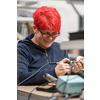 Industrial worker woman soldering cables of manufacturing equipment in a factory. High quality photo