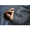 Pretty, young woman sleeping in her bed late in the morning on a weekend - compensating for the lack of sleep