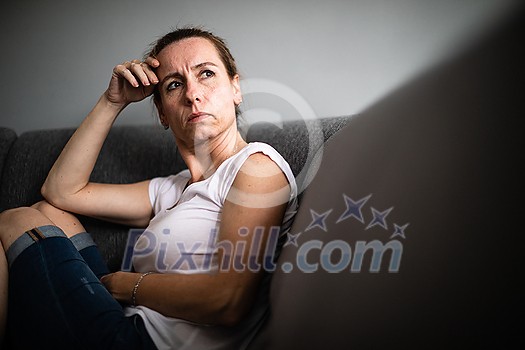 Depressed mid-aged woman at home feeling sad, lonely, anxious (color toned image) Depressed mid-aged woman at home feeling sad, lonely, anxious (color toned image)