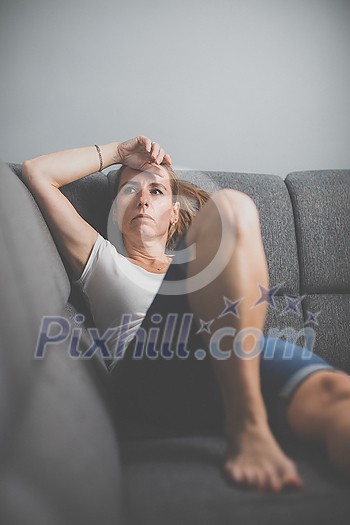 Depressed mid-aged woman at home feeling sad, lonely, anxious (color toned image) Depressed mid-aged woman at home feeling sad, lonely, anxious (color toned image)