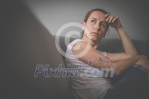 Depressed mid-aged woman at home feeling sad, lonely, anxious (color toned image) Depressed mid-aged woman at home feeling sad, lonely, anxious (color toned image)