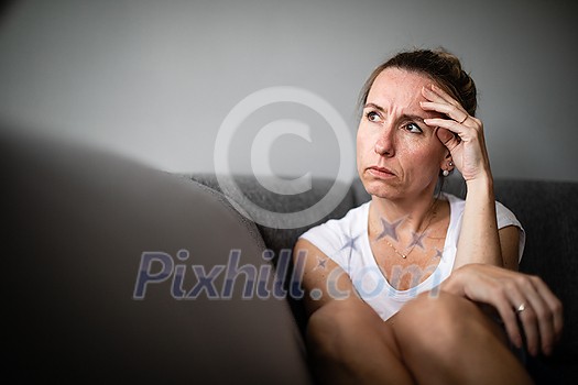 Depressed mid-aged woman at home feeling sad, lonely, anxious (color toned image) Depressed mid-aged woman at home feeling sad, lonely, anxious (color toned image)