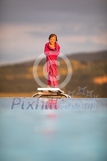 Little girl on a pool's edge, learning to swim and dive. Swimming with kids. Healthy sport activity for children. Sun protection. Water fun.