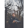 Young man devoting time to his favorite hobby - photography - taking photos outdoor with his digital camera/DSLR