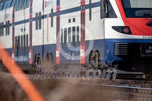 Suburban train on a hot summer day going fast on a modern railway, transporting commuters Suburban train on a hot summer day going fast on a modern railway, transporting commuters