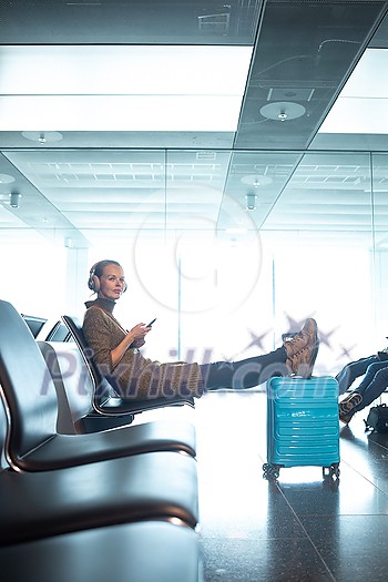 A female traveller waiting for her flight boarding time at the gate of a modern airport in the pre-covid era (color tone image) A female traveller waiting for her flight boarding time at the gate of a modern airport in the pre-covid era (color tone image)