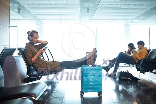 A female traveller waiting for her flight boarding time at the gate of a modern airport in the pre-covid era (color tone image) A female traveller waiting for her flight boarding time at the gate of a modern airport in the pre-covid era (color tone image)