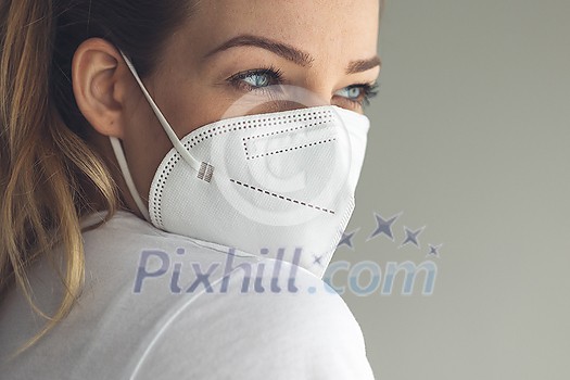 Young woman wearing a face mask during coronavirus and flu outbreak. Virus and illness protection, home quarantine. COVID-19 concept Young woman wearing a face mask during coronavirus and flu outbreak. Virus and illness protection, home quarantine. COVID-19 concept
