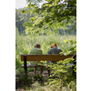 Elderly couple outdoors in summer. Happy elderly couple on a walk. Handsome man and woman senior citizens. Husband and wife of old age against the background of nature.
