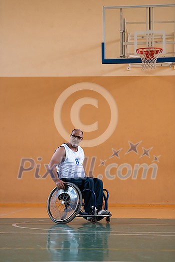 a war invalid in a wheelchair train with a ball at a basketball club in training with professional sports equipment for the disabled. the concept of sport for people with disabilities. High quality photo