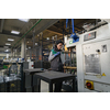a woman working in a modern metal factory assembles parts for a new machine. High quality photo