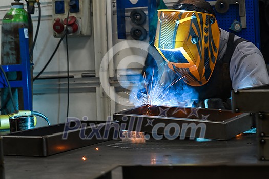 Professional welder performs work with metal parts in factory, sparks and electricity. Industry worker banner. High quality photo Professional welder performs work with metal parts in factory, sparks and electricity. Industry worker banner. High quality photo