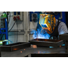 Professional welder performs work with metal parts in factory, sparks and electricity. Industry worker banner. High quality photo