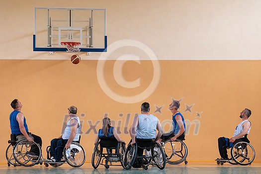 Disabled War veterans mixed race opposing basketball teams in wheelchairs photographed in action while playing an important match in a modern hall. High quality photo Disabled War veterans mixed race opposing basketball teams in wheelchairs photographed in action while playing an important match in a modern hall. High quality photo