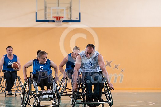 Disabled War veterans mixed race opposing basketball teams in wheelchairs photographed in action while playing an important match in a modern hall. High quality photo Disabled War veterans mixed race opposing basketball teams in wheelchairs photographed in action while playing an important match in a modern hall. High quality photo