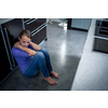 Depressed young woman, sitting on the kitchen floor, feeling down