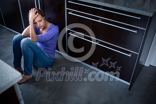 Depressed young woman, sitting on the kitchen floor, feeling down Depressed young woman, sitting on the kitchen floor, feeling down