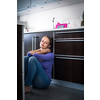Depressed young woman, sitting on the kitchen floor, feeling down