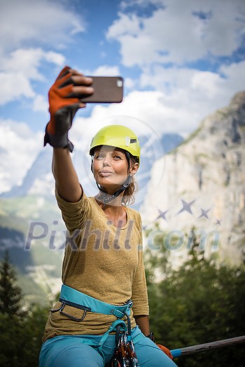 Pretty, female climber on a via ferrata - climbing on a rock in Swiss Alps Pretty, female climber on a via ferrata - climbing on a rock in Swiss Alps