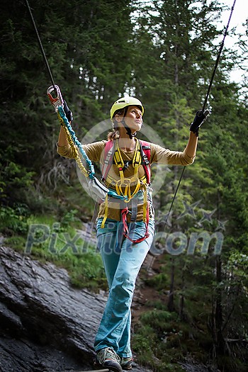 Pretty, female climber on a via ferrata - climbing on a rock in Swiss Alps Pretty, female climber on a via ferrata - climbing on a rock in Swiss Alps