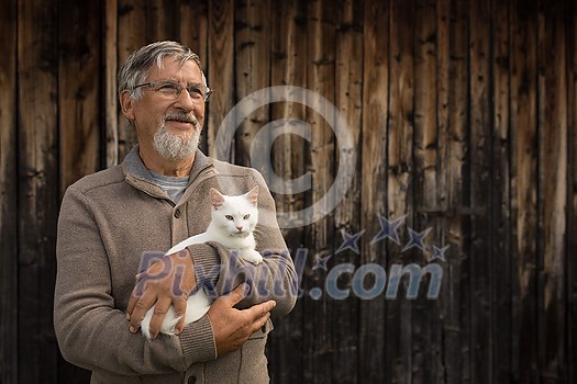 An elderly man holds a cute white kitten and smiles to the camera, selective focus, plenty of copy space An elderly man holds a cute white kitten and smiles to the camera, selective focus, plenty of copy space