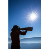 Senior man devoting time to his favorite hobby - photography - taking photos outdoor with his digital camera/DSLR and a big telephoto lens