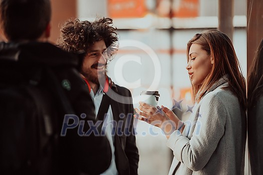 two young people are drinking coffee and taking a break from work in front of the company where they work