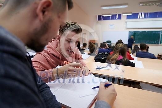 In the Classroom Multi Ethnic Students Listening to a Lecturer and Writing in Notebooks. Smart Young People Study at the College. In the Classroom Multi Ethnic Students Listening to a Lecturer and Writing in Notebooks. Smart Young People Study at the College.