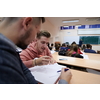 In the Classroom Multi Ethnic Students Listening to a Lecturer and Writing in Notebooks. Smart Young People Study at the College.