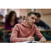 student taking notes while studying in high school.  Portrait of college guy writing while completing assignment.