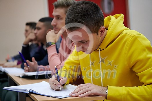 In the Classroom Multi Ethnic Students Listening to a Lecturer and Writing in Notebooks. Smart Young People Study at the College. In the Classroom Multi Ethnic Students Listening to a Lecturer and Writing in Notebooks. Smart Young People Study at the College.