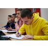 In the Classroom Multi Ethnic Students Listening to a Lecturer and Writing in Notebooks. Smart Young People Study at the College.