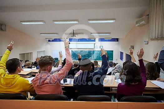 a large group of students raises their hand to answer a question asked by the professor a large group of students raises their hand to answer a question asked by the professor