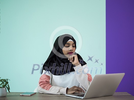 an afro girl wearing a hijab thoughtfully sits in her home office and uses a laptop
an afro girl wearing a hijab thoughtfully sits in her home office and uses a laptop