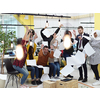 Group of business people having party and  throwing paper in air at modern coworking open space  startup office